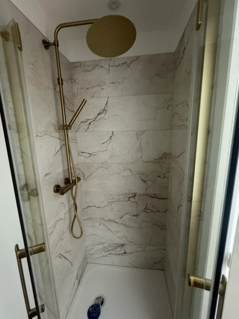 Douche en faïence effet marbre et robinetterie dorée