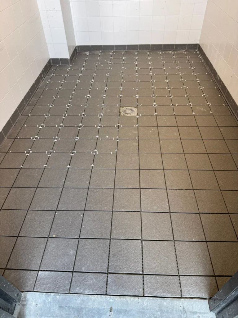 Pose du carrelage de sol avec croisillons, faïence blanche au mur